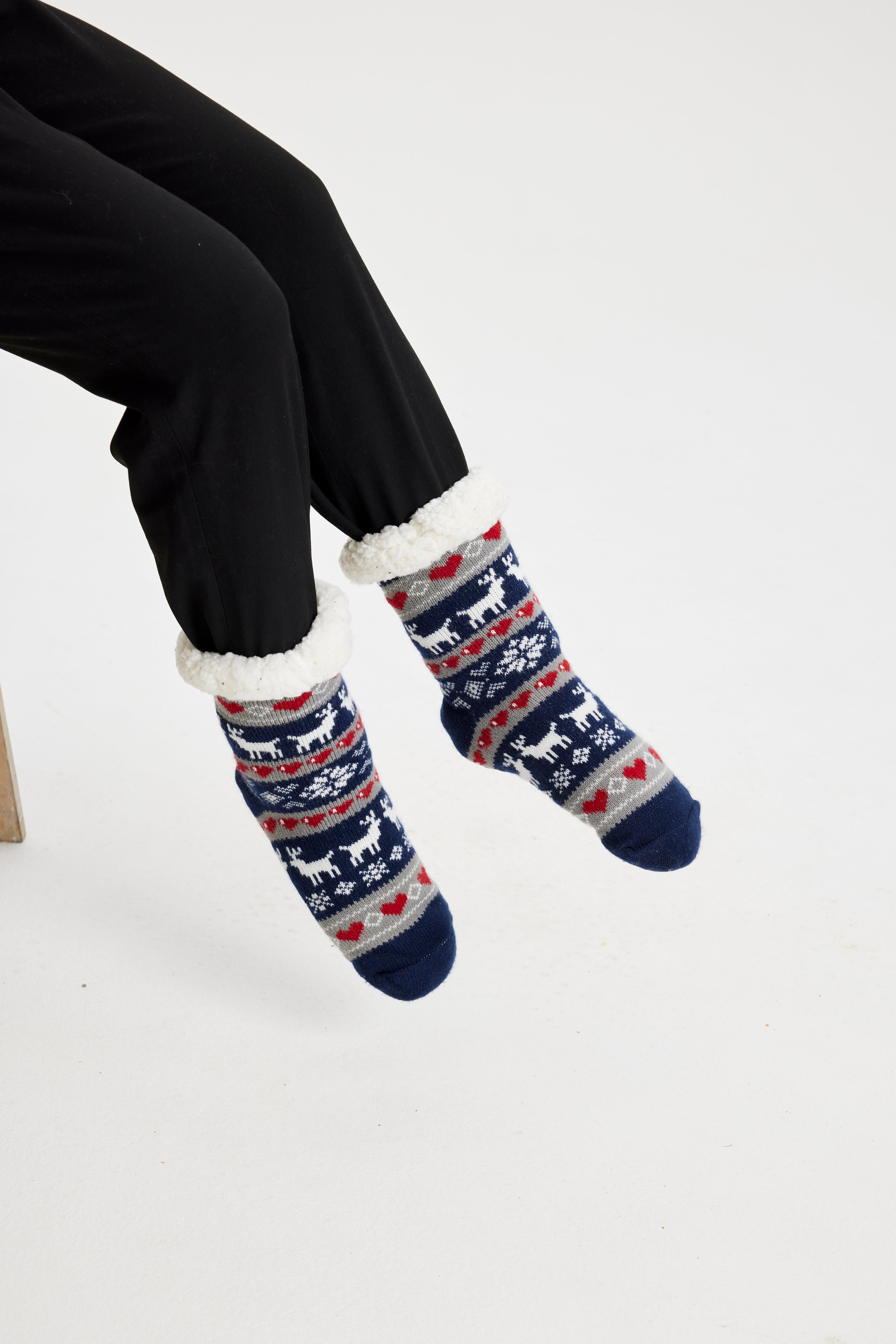 Et par fødder iført fine julesokker med julemønster.